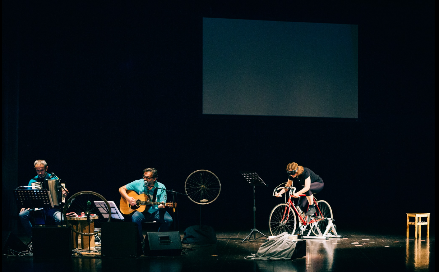 Maria Giulia Campioli interpreta Alfonsina Strada pedalando sulla bicicletta, accompagnata da chitarra e fisarmonica.